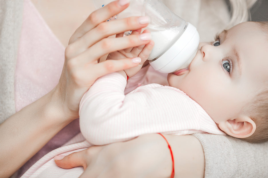 young-mother-feeding-her-little-cute-baby-daughter-with-bottle-of-child-formula-woman-with-her-newborn-baby-at-home-mom-taking-care-of-a-child-alternative-to-breast-feeding