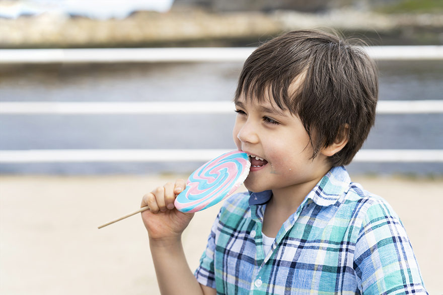 funny-kid-eating-lollipop-happy-little-boy-holding-big-sugar-c