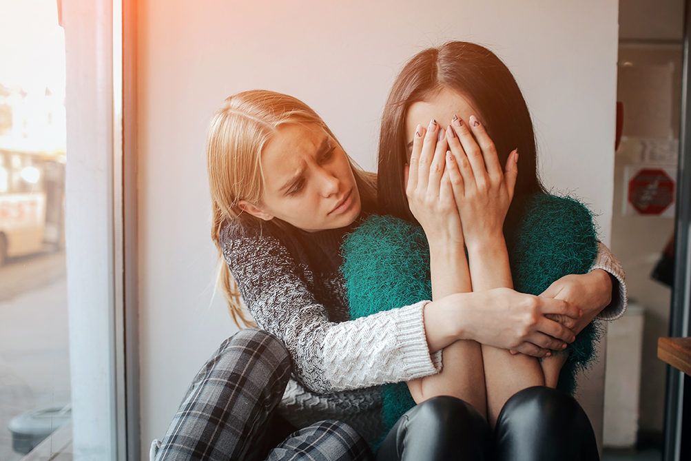 troubled-young-girl-comforted-by-her-friend-woman-supporting-the-girl